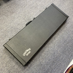 A Chapman ML1 Pro Modern Lunar electric guitar case by Chapman, designed for a dual humbucker, 24-fret model, lies closed on a gray carpeted floor and is photographed from above.