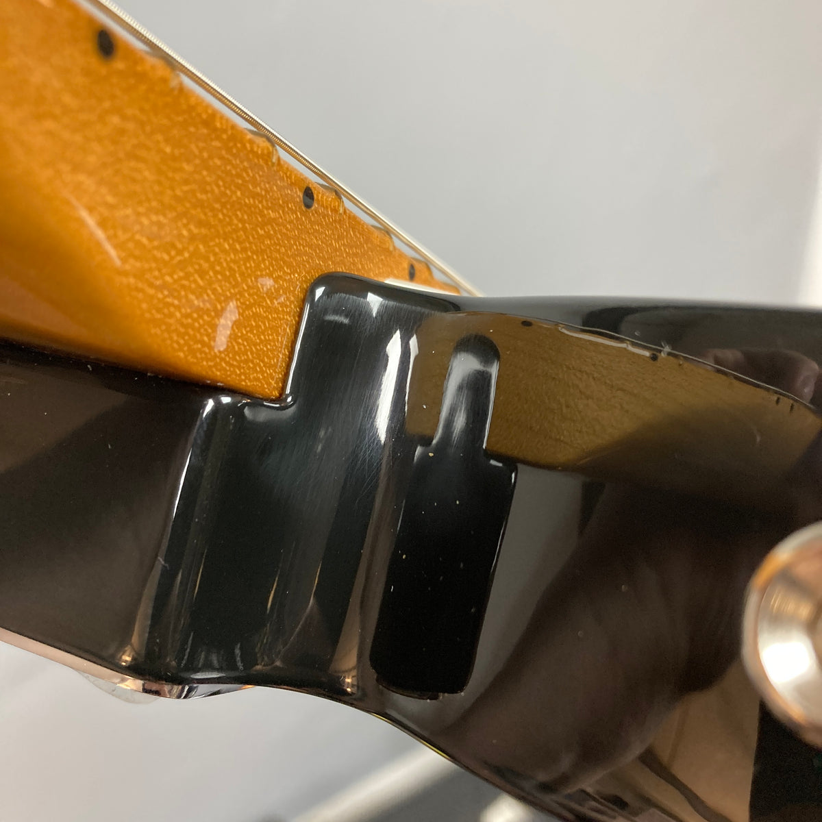 Close-up of the neck joint displaying the connection between the yellow neck and the black semi-hollow ash body of a used Fender Vintera II ’60s Telecaster Thinline by Fender.