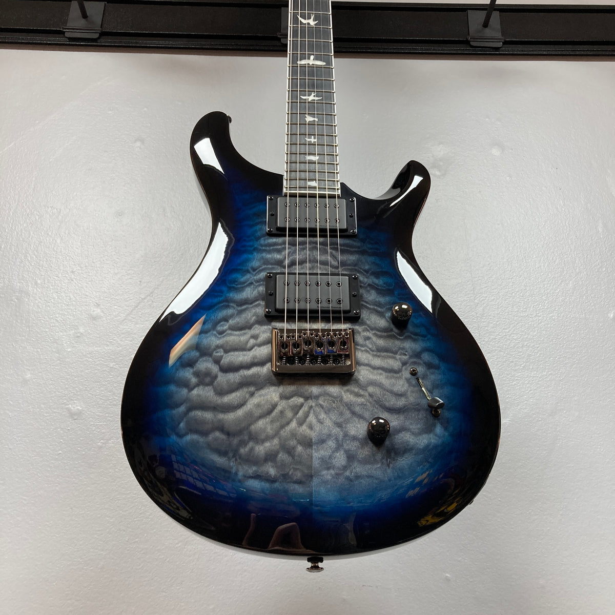 PRS SE Mark Holcomb - Holcomb Blue Burst w/Gigbag Used Consign by PRS, featuring a blue burst quilted maple top, Seymour Duncan humbuckers, and a Floyd Rose bridge on display.