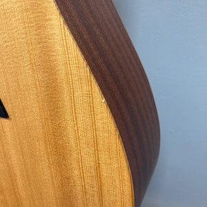 Close-up of a Taylor Academy 10e Acoustic-Electric Guitar w/GigBag body showing the contrast between the light top and darker side against a plain background.
