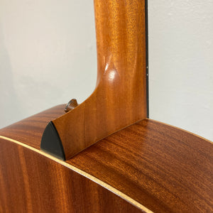 Close-up of a Taylor Academy 10e Acoustic-Electric Guitar w/GigBag neck joint, highlighting the wood grain, smooth finish, and body details against a neutral background.