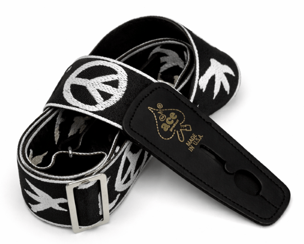 The D'Andrea Ace Pro Lock-It 2" Jacquard Guitar Strap features black jacquard with white peace and dove designs, a metal buckle, and "ace Made in USA" embossed in gold on the leather end—vintage Ace style reissued.