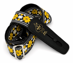 The D'Andrea Ace Pro Lock-It 2" Jacquard Guitar Strap features a black strap with yellow and white flower patterns, silver buckle, black leather ends, and gold "Ace" branding—classic vintage-inspired style made in the USA.
