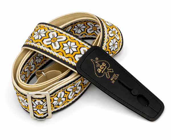 The D'Andrea Ace Pro Lock-It 2" Jacquard Guitar Strap features a red, yellow, and white geometric design, silver buckle, black leather ends stamped “ace” and “Made in USA,” inspired by vintage Ace straps.