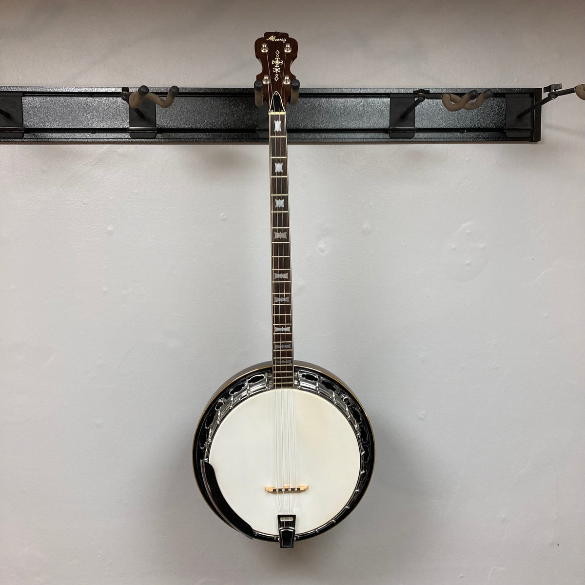 Alvarez Minstrel 4-string Tenor Banjo from the 1970s mounted on a wall.