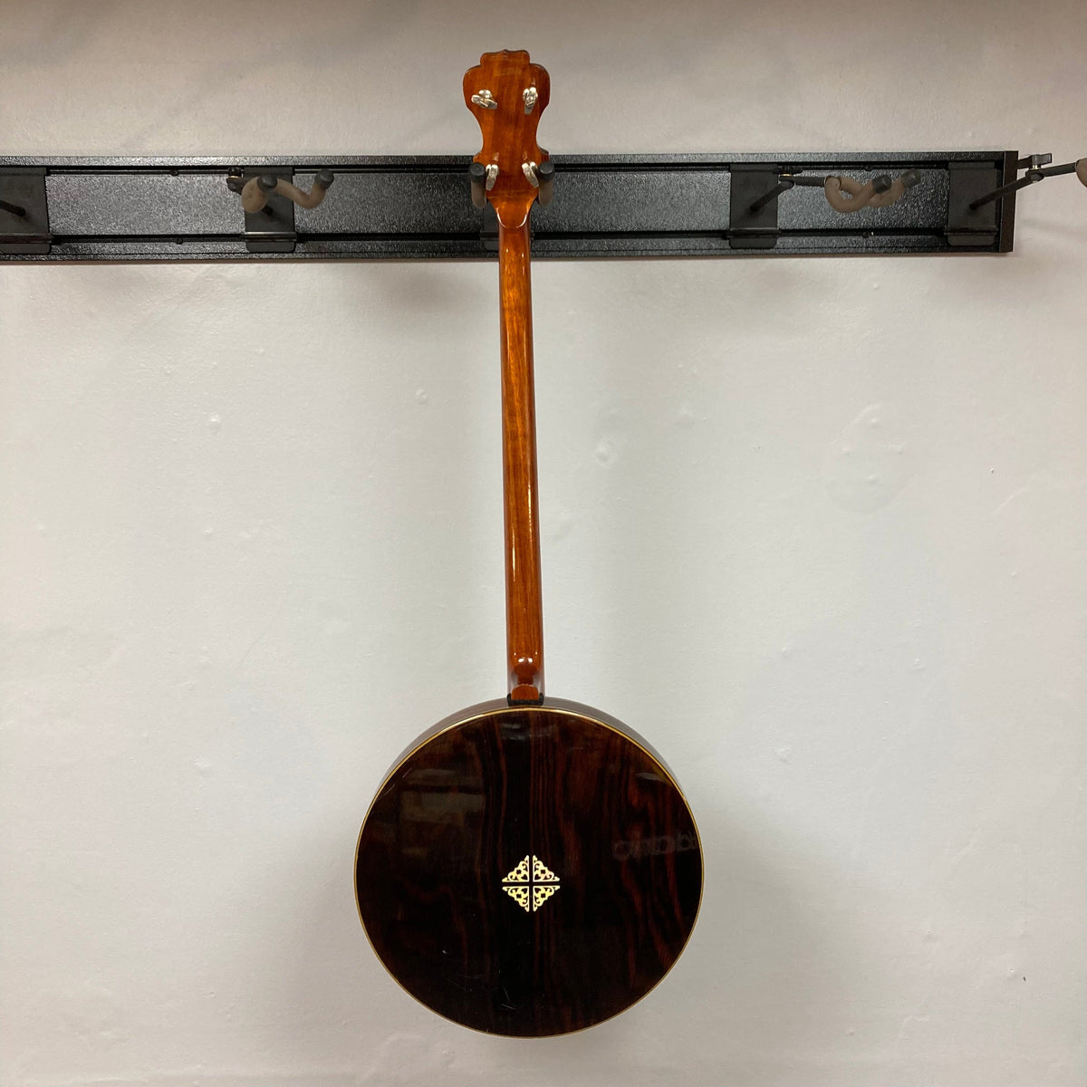 Alvarez Minstrel 4-string Tenor Banjo, 1970s model, displayed on a wall, showcasing intricate fretboard inlays and a mahogany neck with resonator.