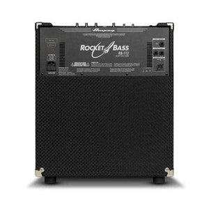 A black Ampeg RB12 Rocket Bass Amp is shown from the back, displaying its input/output panel, top-mounted control knobs, and textured covering. The model name and Ampeg branding are visible on the back panel.