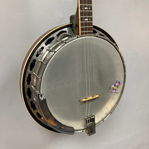 Aria Tenor Banjo 4 String 1970s w/Case hanging on a wall, showcasing its quality craftsmanship and durable hardware.