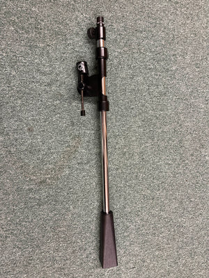 An Atlas Sound PB21XCH Professional Microphone Stand Boom by Atlas Sound rests on a speckled gray carpeted floor, its sleek design reminiscent of studio recording or live sound equipment.