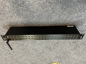 A Black Lion Audio PBR TRS-BT 46-Point Gold-Plated TRS Patchbay with Bluetooth (1 RU), featuring gold-ringed jacks and a black Bluetooth antenna, rests on a gray carpeted surface.