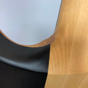 Close-up view of the Chapman ML1 Pro Modern Lunar electric guitar by Chapman, showcasing its elegantly curved body with a smooth gradient transition from natural light wood grain to a sleek black painted section—a hallmark of modern design—featuring dual humbucker pickups.