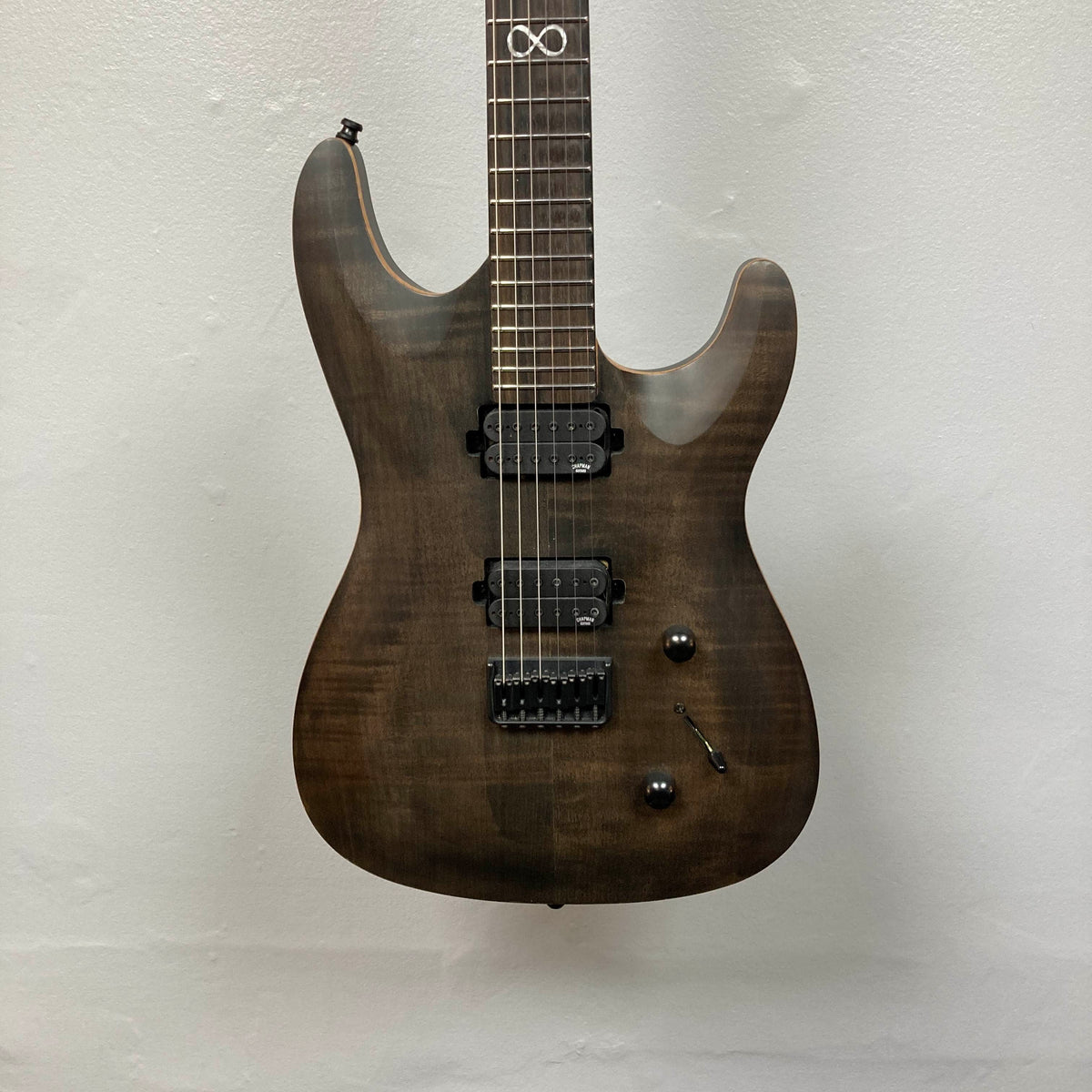 Chapman ML1 Pro Modern Lunar electric guitar by Chapman, featuring a dark wood finish, dual humbucker pickups, 24-fret neck, two control knobs, and a switch, photographed against a plain white wall.
