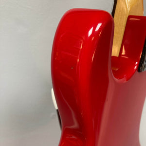 Close-up of a Charvel Model 4 HSS Red w/OHSC Consign electric guitar by Charvel, highlighting a small chip or blemish on the red body near the neck.