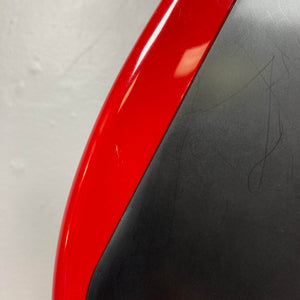 Close-up of a Charvel Model 4 HSS Red w/OHSC Consign electric guitar with curved edges, its black surface showing signs of wear, set against a light gray background—highlighting the vintage character and classic HSS setup.