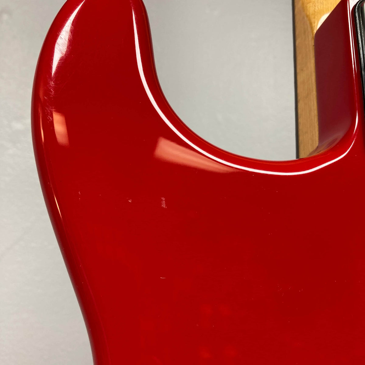 Close-up of the Charvel Model 4 HSS Red w/OHSC Consign electric guitar by Charvel, showing its glossy finish and contoured upper body against a plain background.