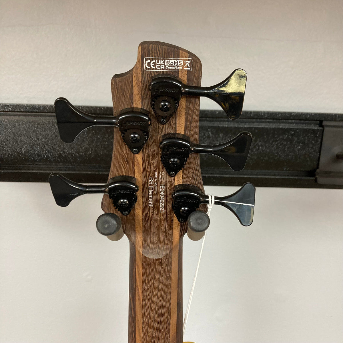 Close-up of the Cort B5 Artisan Element Open Pore Burgundy Red Bass Guitar, highlighting the roasted maple fretboard and Bartolini MK-1 pickups.