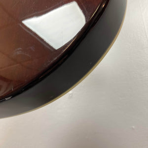 A close-up of the glossy brown Crafter SA-BUB Acoustic Electric Guitar Used Consign captures its edge reflecting light, set against a plain off-white wall—showcasing this Crafter instrument’s plug-in performance appeal.