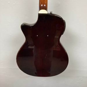 The back of a used Crafter SA-BUB Acoustic Electric Guitar is shown against a white wall, highlighting its dark brown finish, single cutaway design, and two visible dots—perfect for your next plugged in performance.