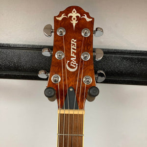 Close-up of the Crafter SA-BUB Acoustic Electric Guitar Used Consign headstock, with six tuning pegs, metal strings, decorative inlay, and Crafter logo on light brown wood. Ideal for both acoustic and electric performance.