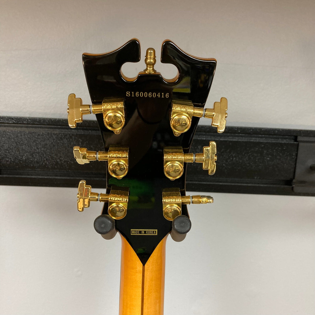 D&#39;Angelico Excel DC Semi-hollowbody guitar with gold hardware and vintage natural finish, showcasing a close-up of the body and knobs.