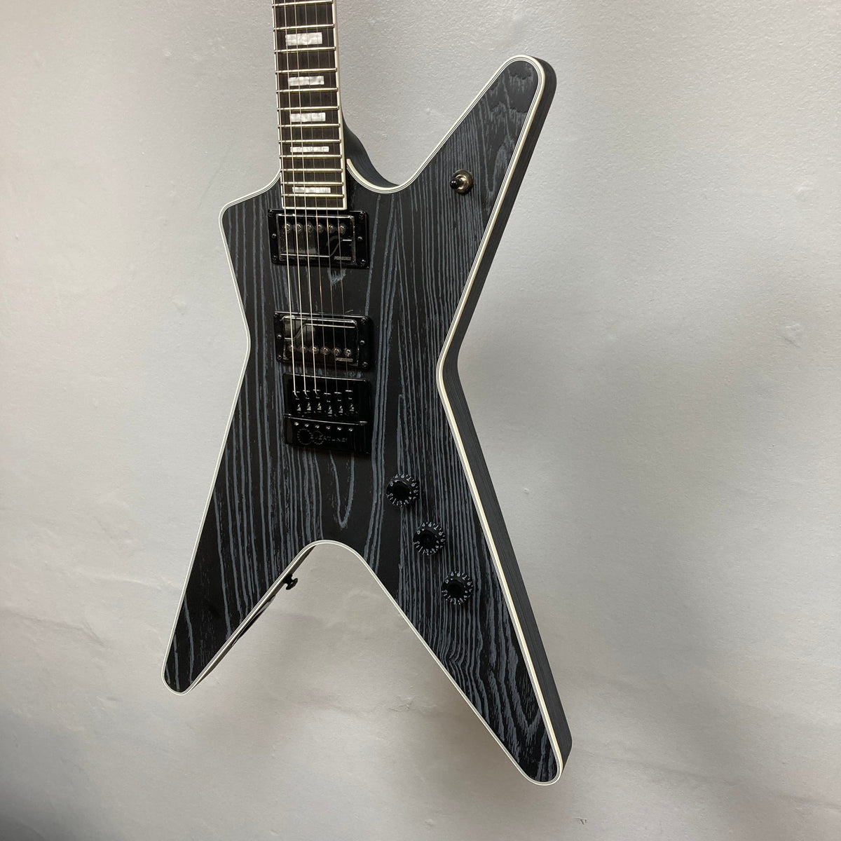 Dean Custom Run #16 ML Sandblasted Grey guitar displayed vertically; highlights include jumbo frets, Evertune bridge, and Fishman pickups for performance excellence.