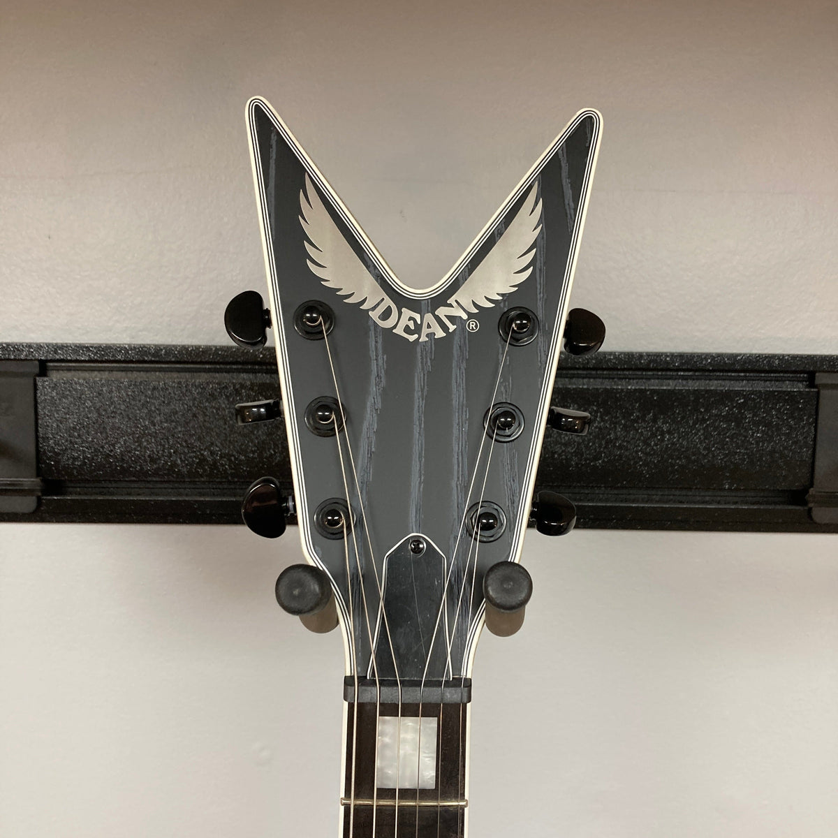 Dean Custom Run #16 ML Sandblasted Grey guitar on a stand, showcasing its iconic ML design with visible Evertune bridge and Fishman pickups.