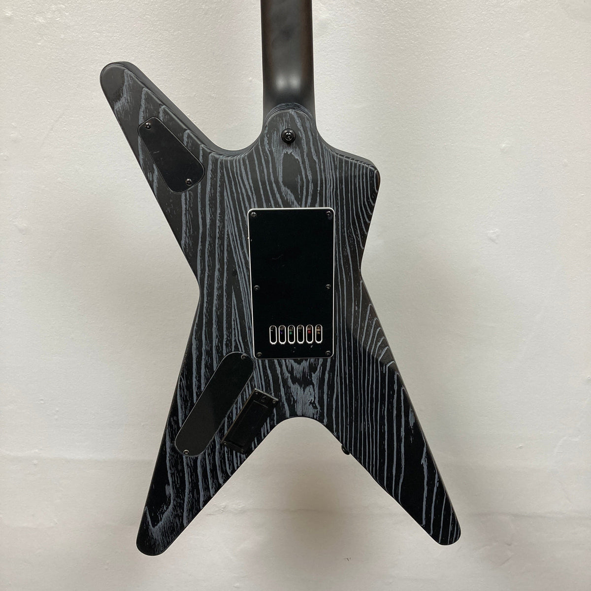 Dean Custom Run #16 ML Sandblasted Grey guitar, featuring a distinctive black and white design with a metal plate and screws, emphasizing precision and style.