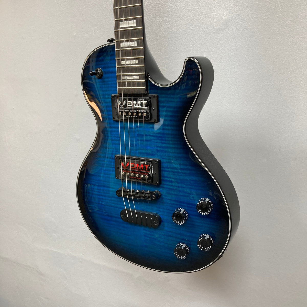 Dean Thoroughbred John Connolly Trans Blueburst electric guitar with a solid mahogany body and flame maple top, displayed against a white wall.