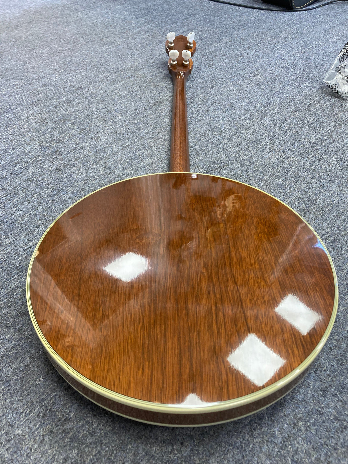 Close-up of the Deering Deluxe 4-String Banjo, highlighting its detailed craftsmanship and strings.