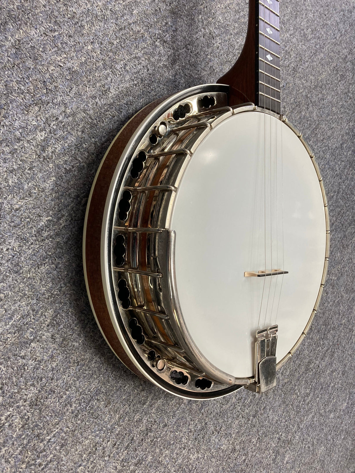 Deering Deluxe 4-String Banjo on a carpet, showcasing its design and craftsmanship.