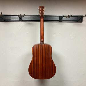 Back view of an Eastman E1D Dreadnought Natural w/Gigbag Used acoustic guitar hanging by its headstock from a wall-mounted rack.