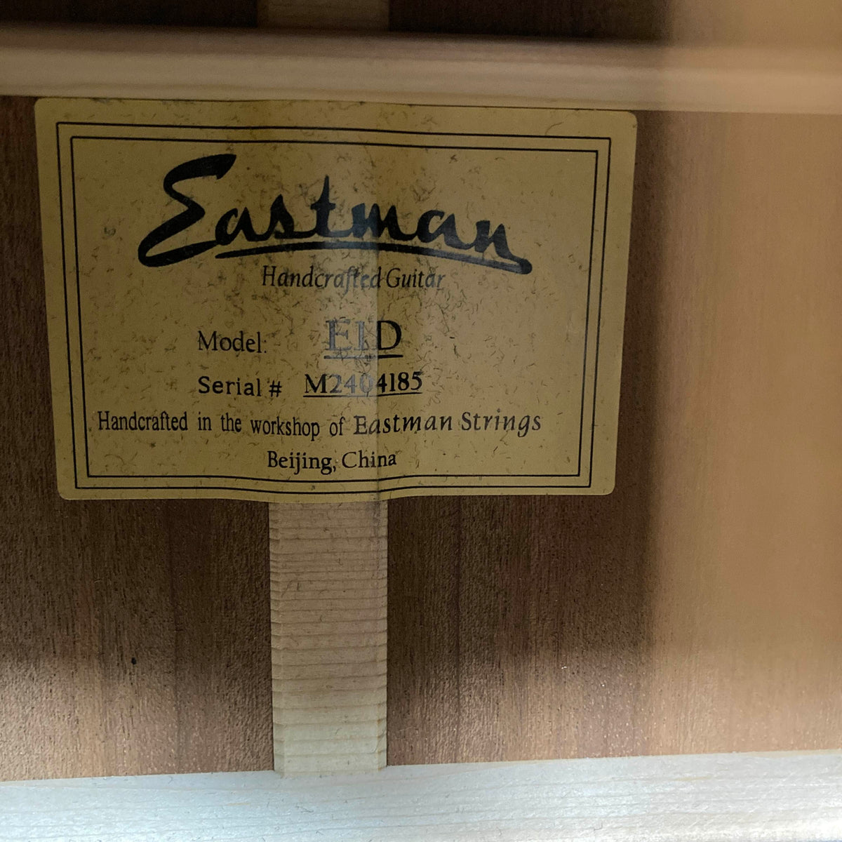 Internal label of an Eastman E1D Dreadnought Natural w/Gigbag Used acoustic guitar, showing model E1D, serial number M2404185, and origin information.