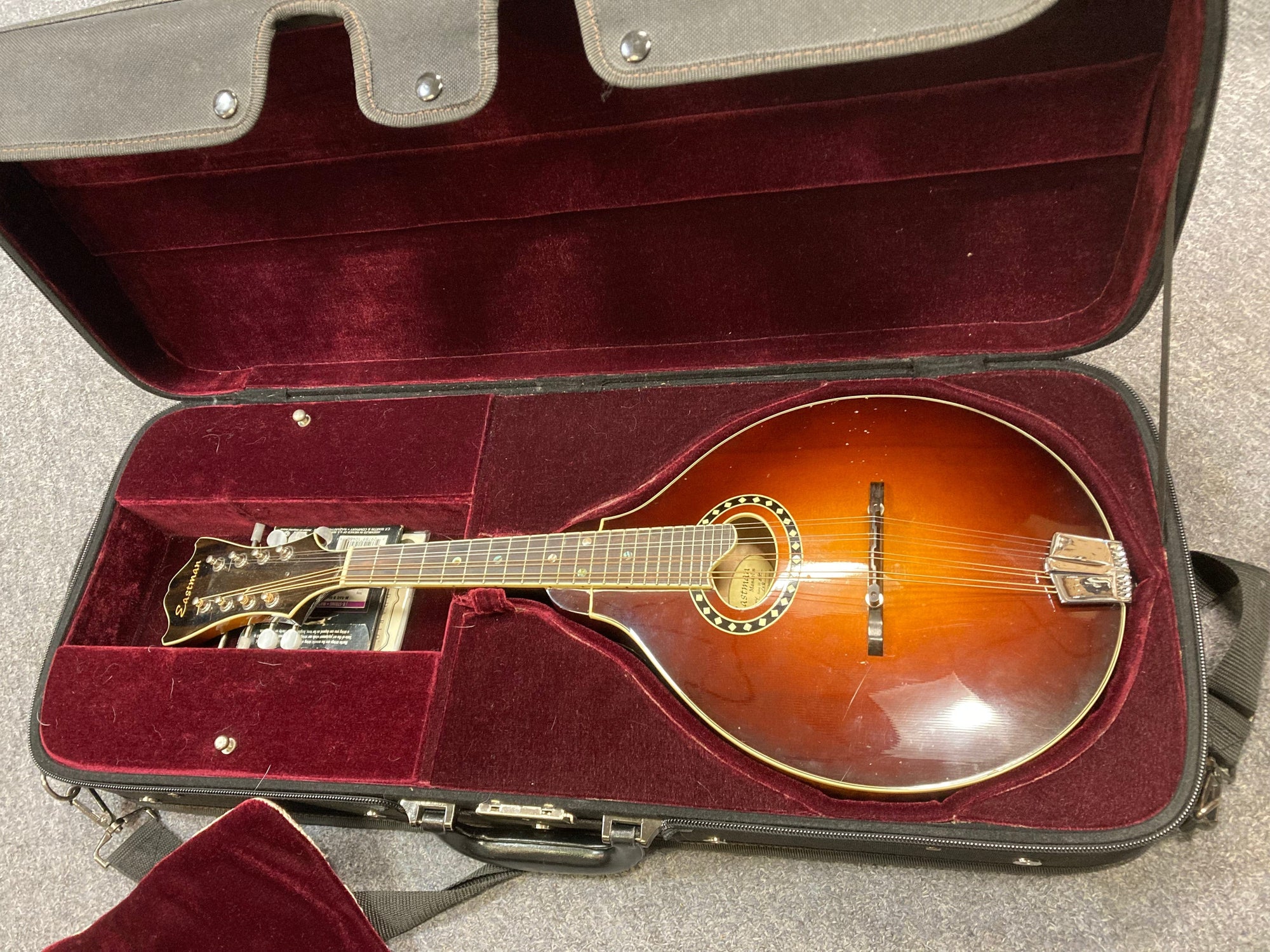 Eastman MD604-GB A-Style Oval-Hole Mandolin displayed in its protective case, highlighting its craftsmanship as a quality string instrument.