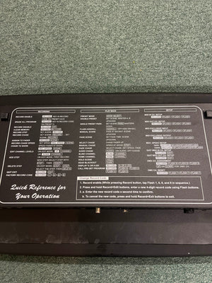 The Elation Scene Setter 24-Channel DMX Dimmer Console features a black control panel with white text and button labels, showing programming and playback instructions. It is placed on green carpet, providing efficient lighting control for any setup.