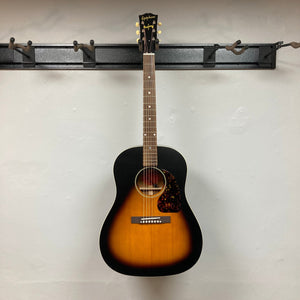 Epiphone 1942 Banner J-45 Vintage Sunburst acoustic guitar, displayed on a wall, showcasing its classic design and craftsmanship. Includes hardshell case.