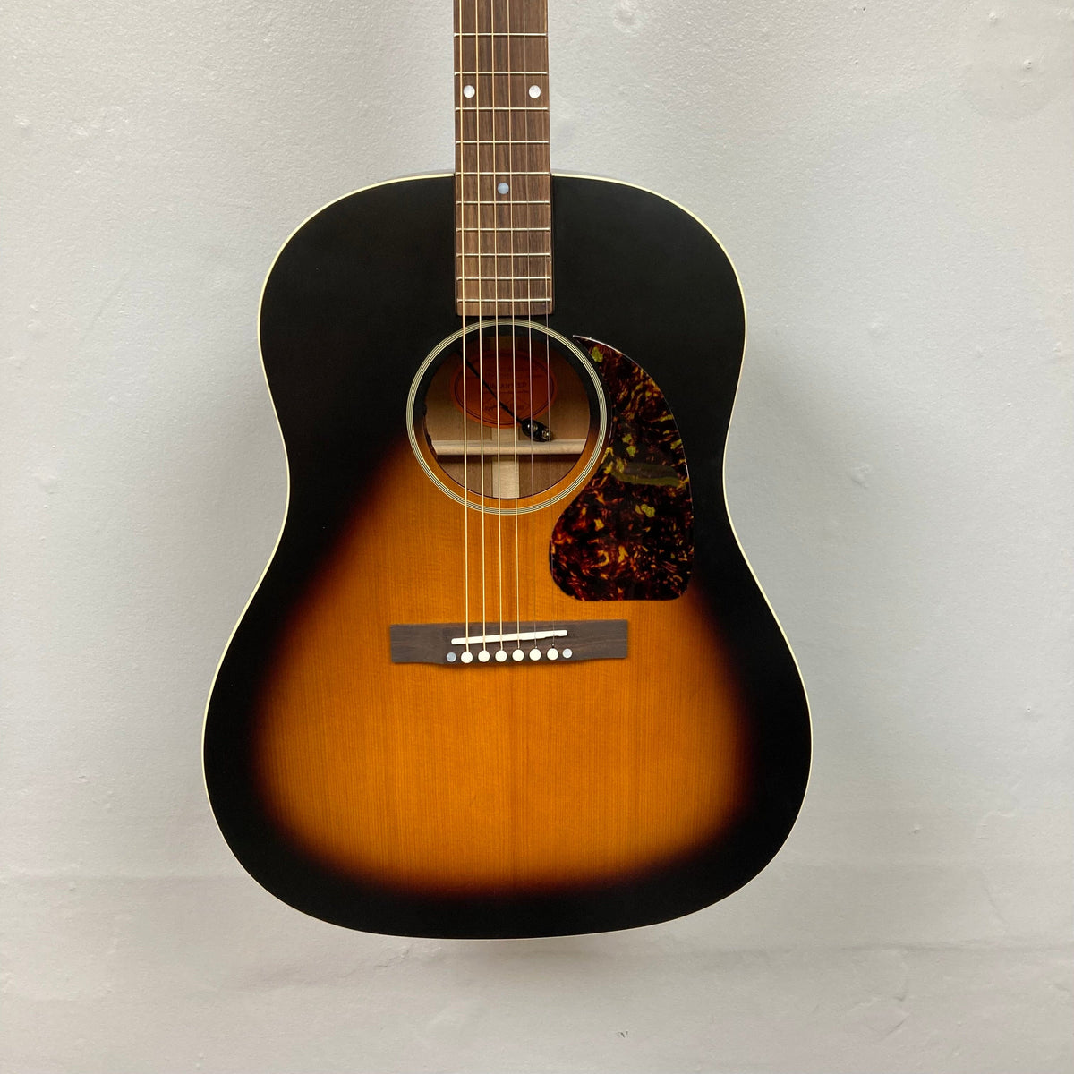 Epiphone 1942 Banner J-45 Vintage Sunburst acoustic guitar, close-up view of strings and body, displayed with case.