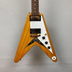 Epiphone 1958 Korina Flying V guitar, close-up showing strings and neck, crafted with solid Korina body and gold hardware, includes a hardshell case.