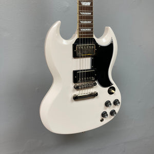 Epiphone 1961 Les Paul SG Standard Aged Classic White electric guitar with distinctive body contours and devil horns design, displayed on a wall.