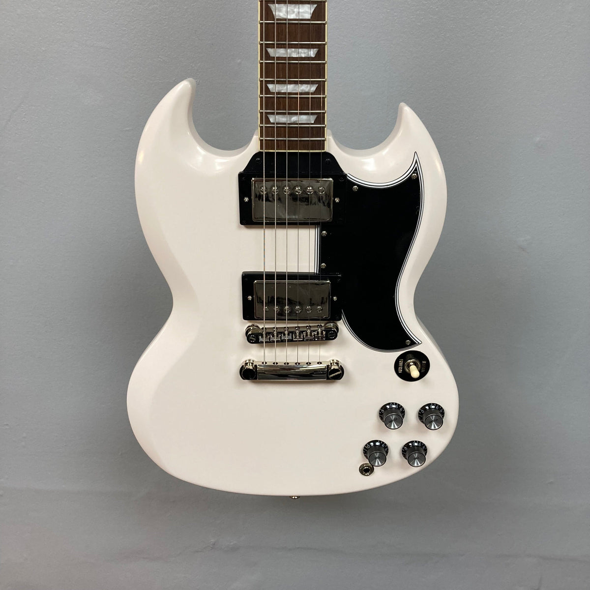 Epiphone 1961 Les Paul SG Standard Aged Classic White electric guitar with distinctive devil horns and vintage-style hardware.