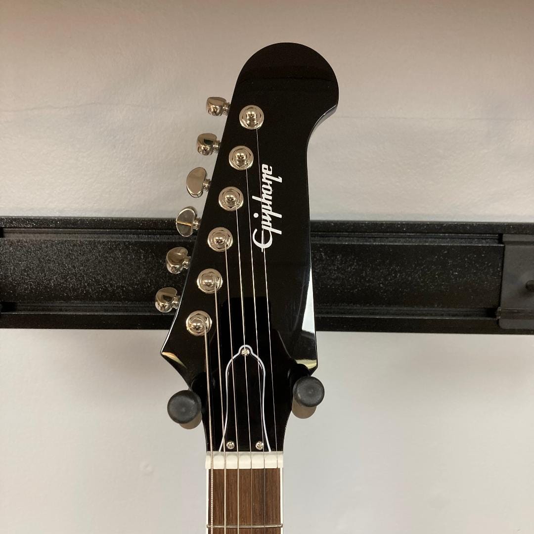 Epiphone Dave Grohl DG-335 guitar on a stand, showcasing its iconic design and craftsmanship, including the distinctive headstock and pickups.