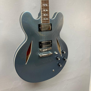 Epiphone Dave Grohl DG-335 guitar with visible strings and pickups, showcased on a wall.