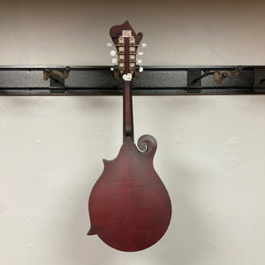 Epiphone F-5 Studio Mandolin in Wine Red Satin displayed on a wall, showcasing its F-style body and craftsmanship.