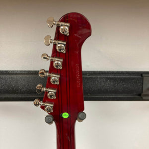 Epiphone Firebird Wine Red w/Gigbag electric guitar by Epiphone features chrome tuning pegs, a serial number on the back of the headstock, a green inspection sticker, and visible neck-through-body design as it hangs on a wall hanger.