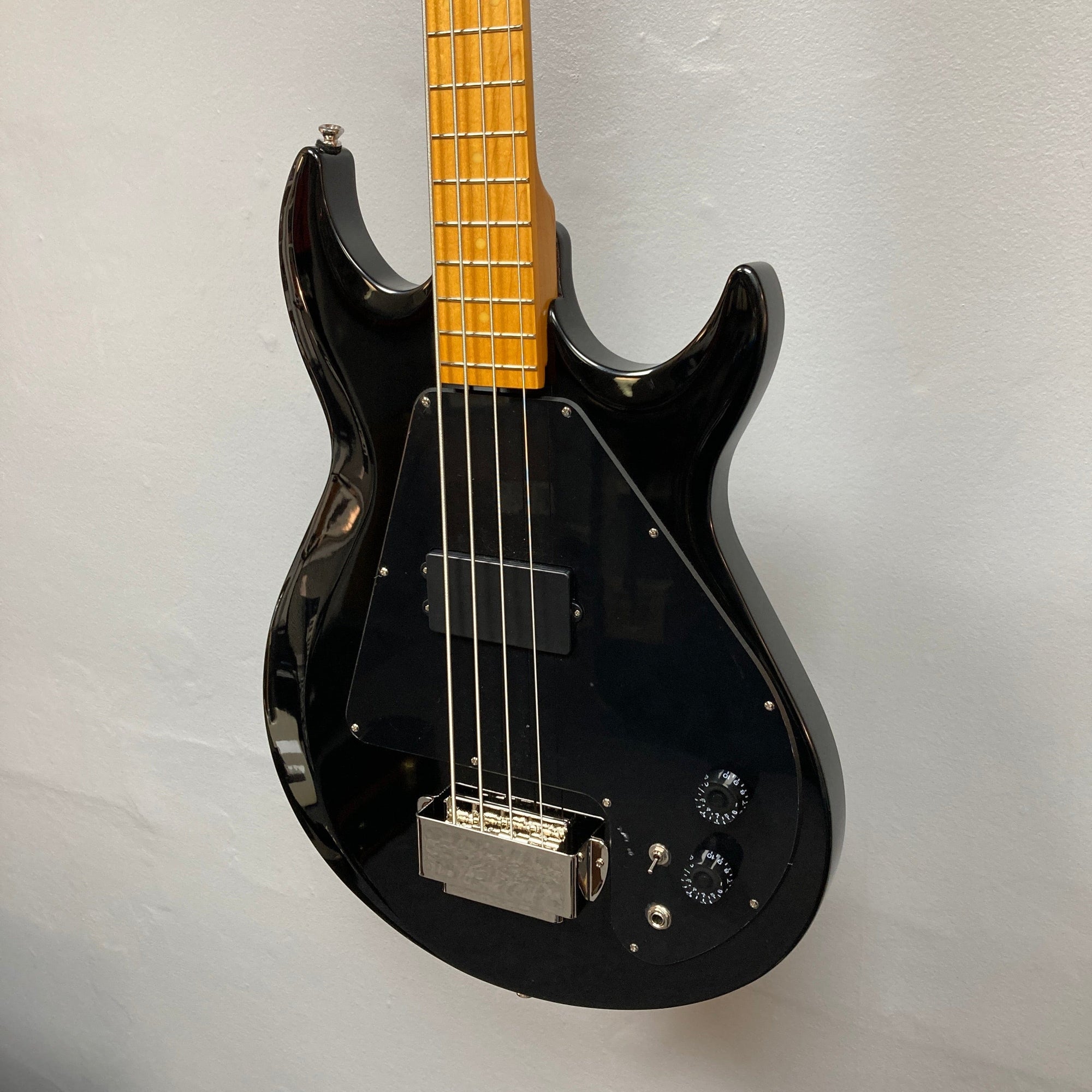 Epiphone Grabber Bass Ebony, featuring a sleek black body and yellow neck, highlighting its intricate strings and dials, ideal for music enthusiasts.