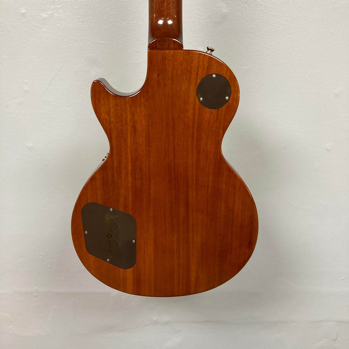 The back of the Epiphone Les Paul 1957 Goldtop Reissue Blem w/Case features two plastic cover plates and a smooth, glossy finish, displayed against a white background.