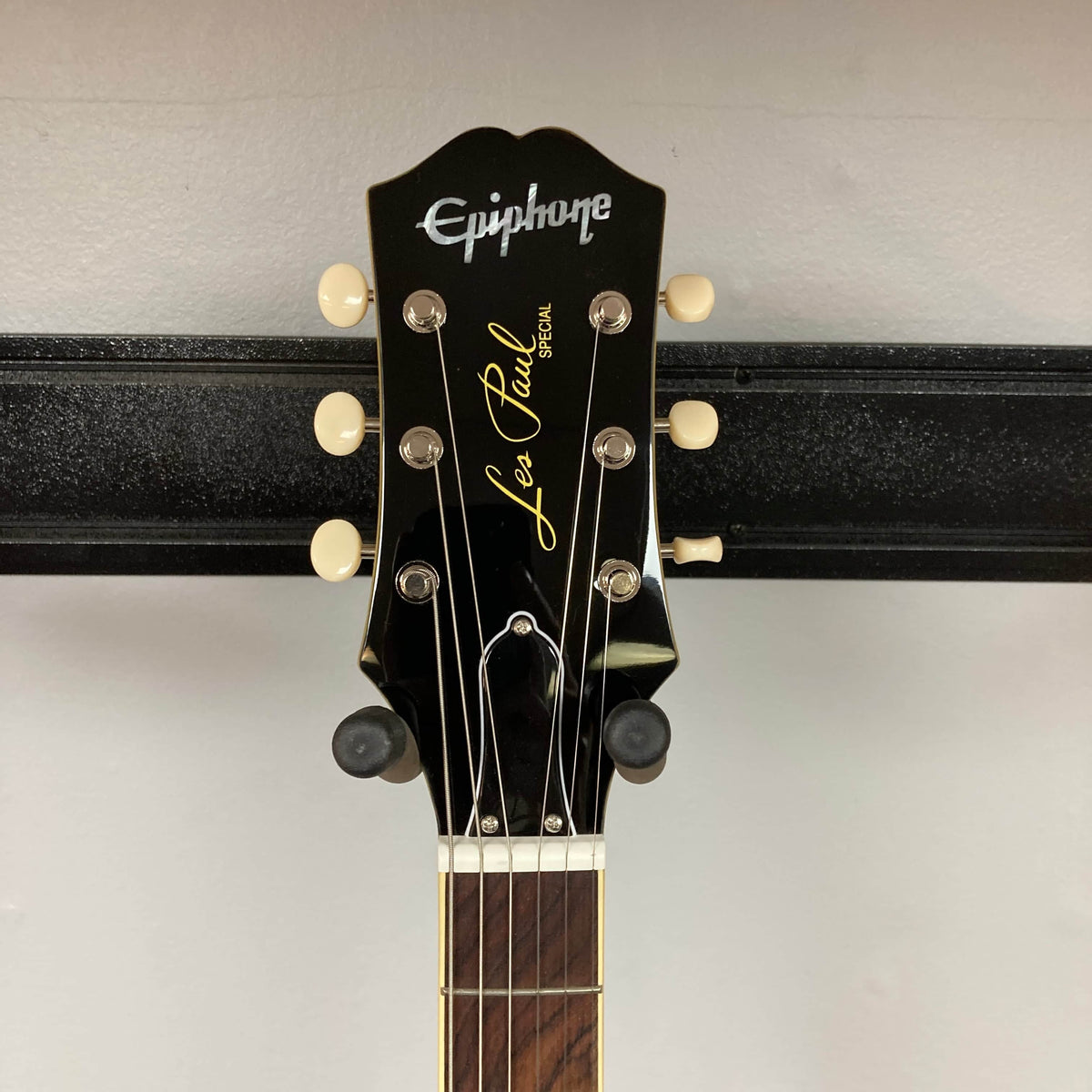 Close-up of the headstock on an Epiphone Les Paul Special Double Cut TV Yellow w/Gigbag, highlighting its tuning pegs and Epiphone logo against a plain background.