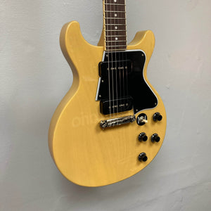 An Epiphone Les Paul Special Double Cut TV Yellow electric guitar with a 60s SlimTaper neck, black pickguard, four control knobs, and dual pickups is shown against a plain light-colored wall. Includes gigbag. Brand: Epiphone.