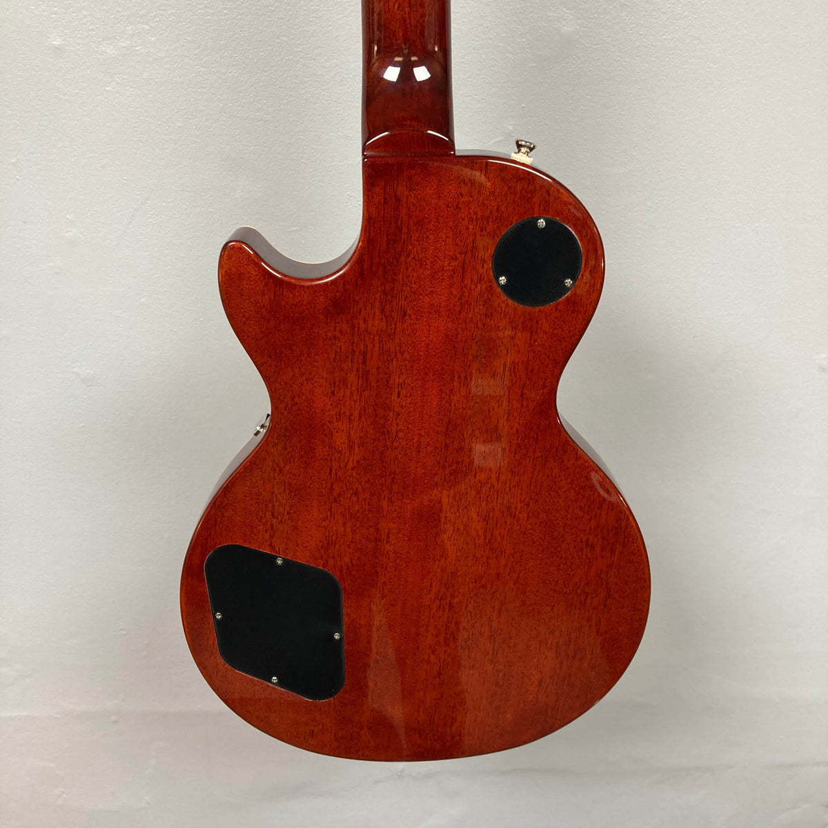 Back view of an Epiphone Les Paul Standard 60s Figured Iced Tea Burst electric guitar with two black plastic access plates, shown against a plain white background. Includes gigbag.