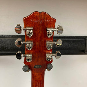 Close-up of the back of an Epiphone Les Paul Standard 60s Figured Iced Tea Burst w/Gigbag headstock, showing six tuning pegs, a serial number, and a "hand crafted in China" label.