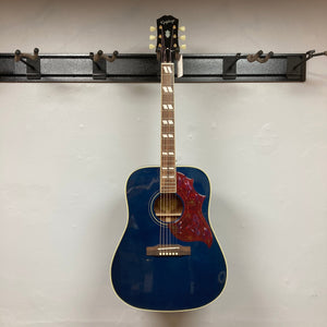 Epiphone Miranda Lambert Bluebird Studio - Bluebonnet guitar with red design, displayed on a wall, features a hummingbird pickguard and onboard electronics.